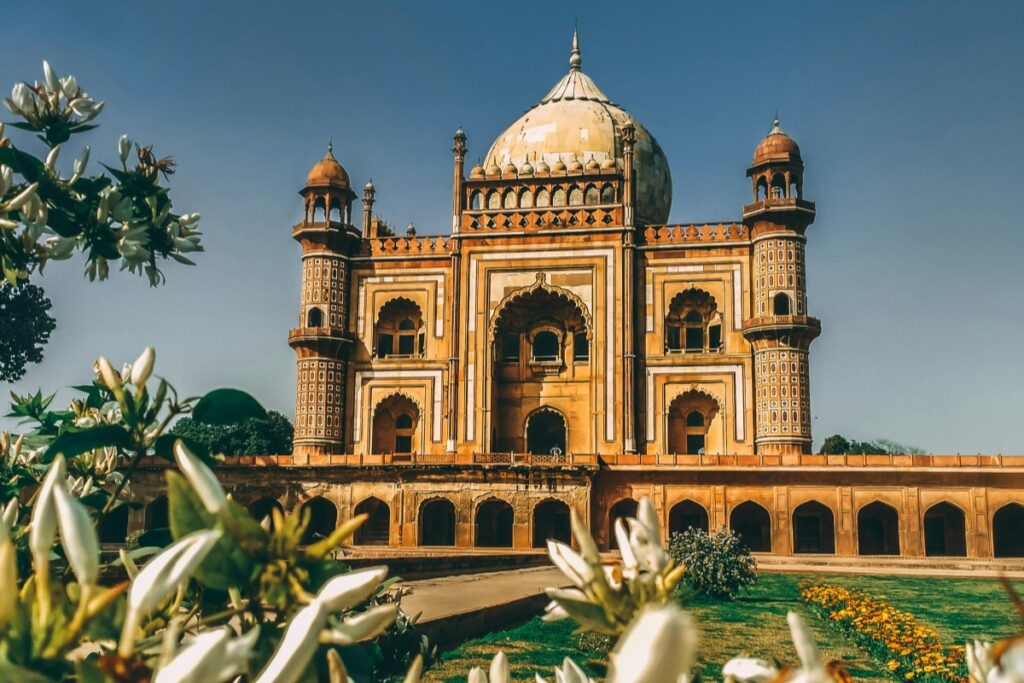 यह चित्र एक सुंदर, पारंपरिक भारतीय इमारत को दर्शाता है। इमारत के साथ - साथ, इसके चारों ओर सुंदर फूल और हरियाली भी है। जिस प्रकार यह इमारत अपनी सुंदरता से आकर्षित करती है, उसी प्रकार Chingari ऐप पर मार्केटिंग करने के 5 असरदार तरीके हैं - स्पष्ट और आकर्षक सामग्री बनाना, ट्रेंडिंग विषयों का उपयोग करना, साथियों के साथ सहयोग करना, प्रतियोगिताएं और इनाम प्रदान करना और अपने दर्शकों के साथ सीधे संवाद में रहना।